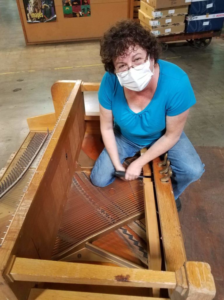Dismantling a worn out piano for the school district.